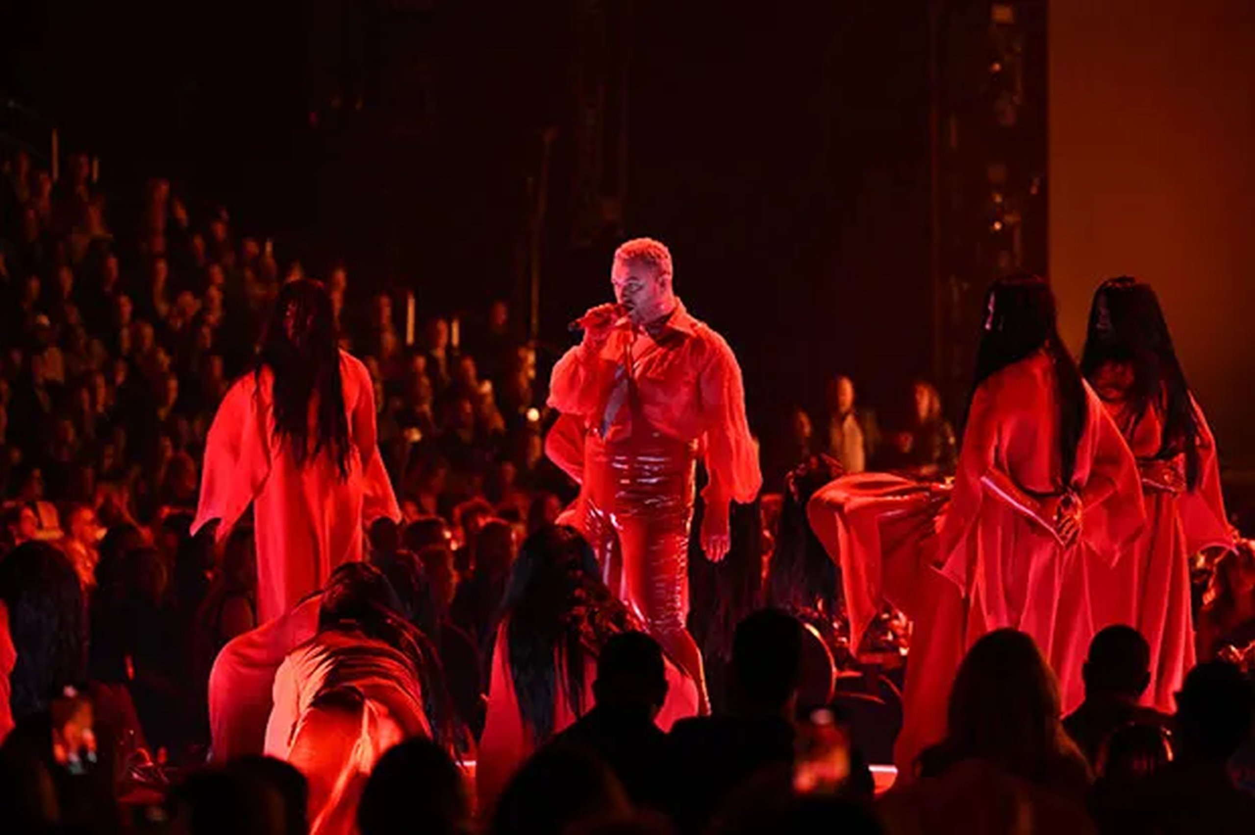 Singer and his dancers performing wearing red outfits